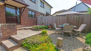 a patio with an umbrella and a table and chairs at Cockleshell Croyde Sleeps 4 By the Seaside in Croyde
