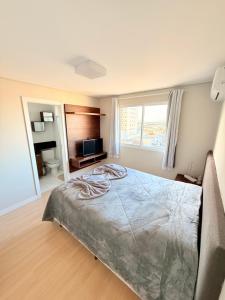 Un dormitorio con una cama grande y un televisor. en Exclusivity in Itajaí Port with Wi-Fi and Jacuzzi, en Itajaí
