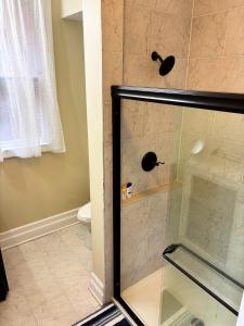 a shower with a glass door in a bathroom at Nintendo, Filtered H2O, Cafe, Central, Self-Check in Troy +24 photos
