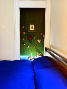 une chambre avec un lit bleu et un mur vert dans l'établissement Nintendo, Filtered H2O, Cafe, Central, Self-Check, à Troy