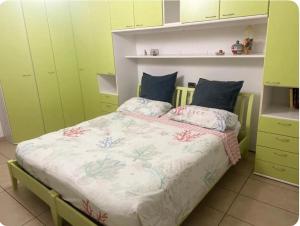 Una cama en una habitación con armarios verdes. en B&B LA Sara INDIRIZZO VIA SERAFINO CALINDRI N 1, en Bolonia