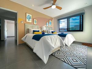 a bedroom with a large bed and a ceiling fan at Apartment with Private Terrace, Pool and Beach Club Access in Playa del Carmen