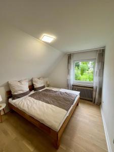 a bedroom with a large bed and a window at Ferienhaus am Vogelsang in Meschede