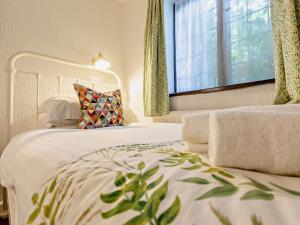 a bedroom with a white bed and a window at 2 Bed in Minehead 90925 in Minehead
