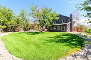 a large yard in front of a black house at Large 4 Bedroom Home with Hot Tub and Fenced Yard - NO XTRA FEES! in Grand Junction