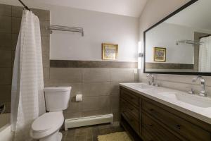 a bathroom with a toilet and a sink and a mirror at Large 4 Bedroom Home with Hot Tub and Fenced Yard - NO XTRA FEES! in Grand Junction +18 photos