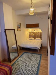 a bedroom with two beds and a mirror and a rug at Casa Jueliatte in Collioure