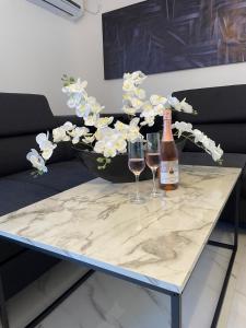 a table with two glasses and a bottle of wine at Second home apartment - rose gold in Kustići +11 photos