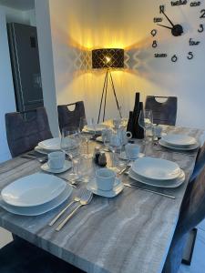 a wooden table with plates and silverware on it at Second home apartment - rose gold in Kustići