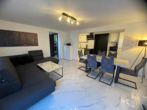 a living room with a couch and a table and chairs at Second home apartment - rose gold in Kustići