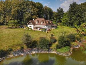 eine Luftaufnahme eines Hauses mit einem Teich in der Unterkunft La Roquetière, Domaine Paradisiaque pour 12 personnes in Ledeuix