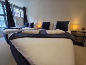 two large beds in a room with two lamps at Modern Apartment 8 in Town Centre in Ipswich