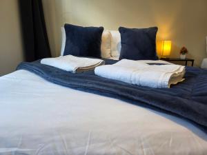 a bed with a blue blanket and pillows on it at Modern Apartment 8 in Town Centre in Ipswich