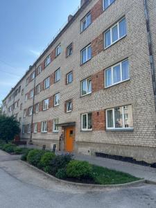 a large brick building with a orange door at Gemma Apartments in Talsi