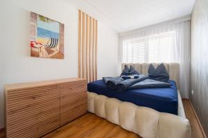 a bedroom with a large bed with blue sheets at Keszeg Villa Zamárdi in Zamárdi