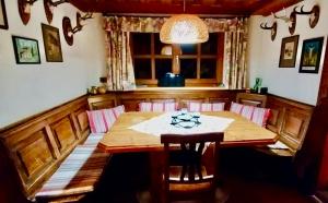 a dining room with a wooden table and chairs at Waldnerhütte in Hermagor