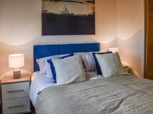 een slaapkamer met een blauw bed met 2 kussens bij Sandymouth Cottage in Marhamchurch +7 foto's