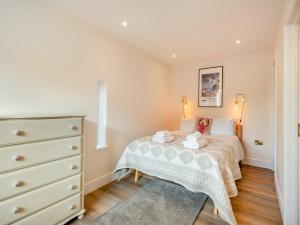 a small bedroom with a bed and a dresser at Beaches in Overstrand