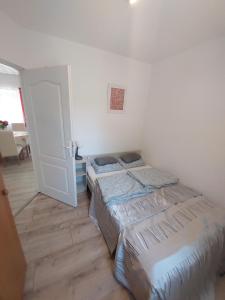 two beds are in a room with a door at Pipacs Vendégház Berekfürdő in Berekfürdő