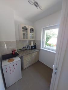 a kitchen with a white stove and a window at Pipacs Vendégház Berekfürdő in Berekfürdő