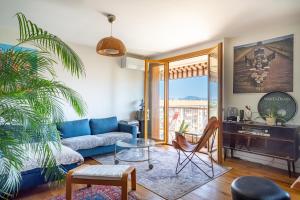 un salon avec un canapé bleu et une table dans l'établissement Spacieux appartement au calme proche de la mer, à Toulon