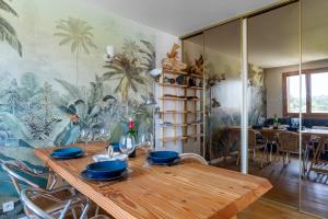 une salle à manger avec une table en bois avec des assiettes bleues dans l'établissement Spacieux appartement au calme proche de la mer, à Toulon