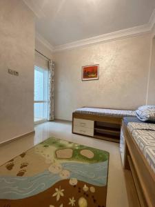 a small bedroom with a bed and a rug at Bel appartement avec piscine vue mer & golf in Asilah
