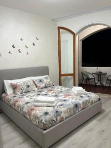 a bedroom with a bed with flowers on it at Garden Lake Apartment in Peschiera del Garda