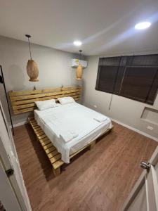 a bedroom with a large bed with a wooden headboard at Wonderful trinity beach house in crespo. in Cartagena de Indias