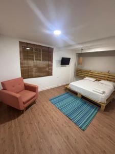 a bedroom with a bed and a chair and a rug at Wonderful trinity beach house in crespo. in Cartagena de Indias +51 photos