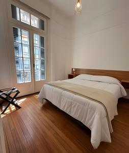 a white bedroom with a large bed and large windows at A metros de todo - Moderno. Hasta 7 pax. #26 in Buenos Aires