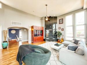 a living room with a large couch and a fireplace at Iconic Downtown Colorado Springs Penthouse with 2000 Sq Ft Rooftop Deck, 10 Person Hot Tub and Stunning Mountain Skyline Views, Two Fireplaces, and Two Lavish Primary Suites in Colorado Springs