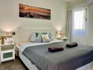 Un dormitorio con una cama con almohadas encima. en Casa Tucan - two bedrooms, heated pool, city and ocean views, en Patalavaca 18 fotos más