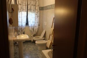a bathroom with a toilet and a sink and a toilet istg at Sotto la Rocca in Angera