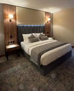 a large bed in a hotel room with two lamps at Comfort sky Hotel11 in Cairo