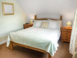 a bedroom with a large bed with two night stands at Apple Blossom Cottage - Uk46648 in Cheddar