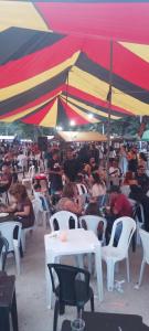 a group of people sitting at tables under an umbrella at Lapa Casa Hostel in Rio de Janeiro