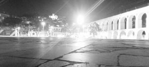 an empty street at night with a building with lights at Lapa Casa Hostel in Rio de Janeiro