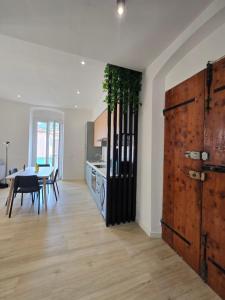 a kitchen and dining room with a large wooden door at Ermanno s Home 5terre stazione centro città in La Spezia