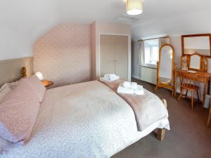 a bedroom with a bed and a table and a mirror at Cherry Tree Cottage - Uk46659 in Cheddar