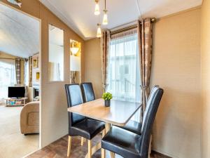 ein Esszimmer mit einem Holztisch und schwarzen Stühlen in der Unterkunft Coastal Retreat in Ilfracombe