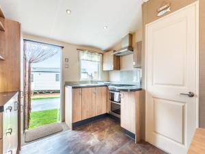 eine Küche mit einer Tür, die sich zu einer Küche mit einem Fenster öffnet in der Unterkunft Coastal Retreat in Ilfracombe + 20 Fotos