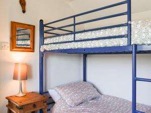 a bedroom with two bunk beds and a table at Bray View Cottage in Davidstow