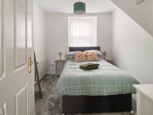 een slaapkamer met een bed met een groene deken bij Guise Cottage Uk46303 in Tough