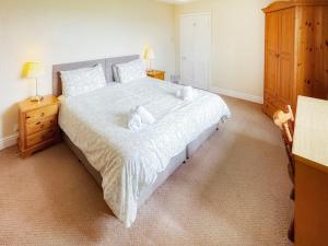 a bedroom with a large bed and a wooden dresser at Latrigg View - Uk45177 in Threlkeld