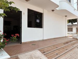 une porte ouverte d'un bâtiment blanc avec une fenêtre dans l'établissement Madili del Mar II, à Santiago