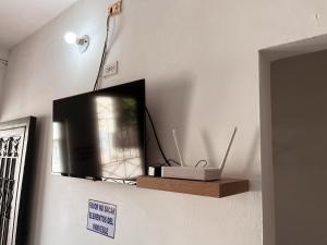 une télévision posée sur un mur avec une étagère en bois dans l'établissement Madili del Mar II, à Santiago