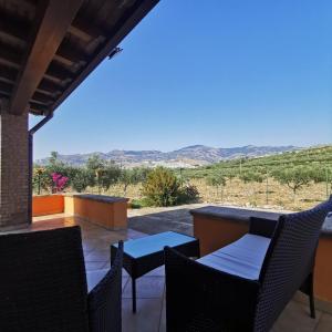 un patio con sedie, tavoli e vista sul deserto di Casa L'ulivo Burgio Nature view a Burgio