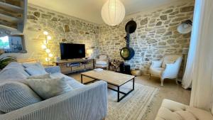 a living room with a blue couch and a tv at Ty Leroux - wifi - centre bourg in Crozon