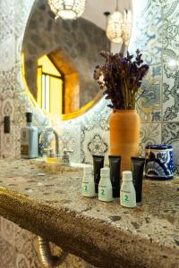 a bathroom counter with a sink and a vase with flowers at Casa Trujillo in Capilla de Guadalupe +46 photos